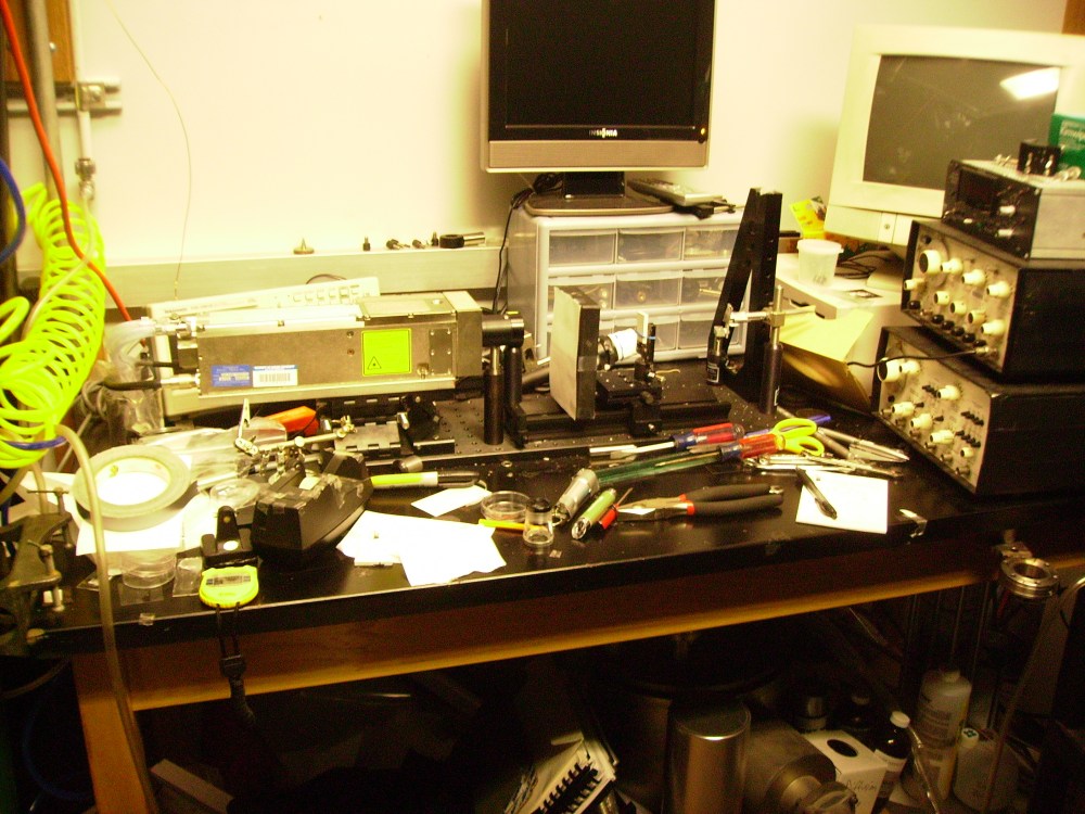 Tanya Mikulas plays with lasers on a cluttered lab bench. Laser ablation to create a prototype of a novel boron nitride contact mask,, Tanya Mikulas, 2010